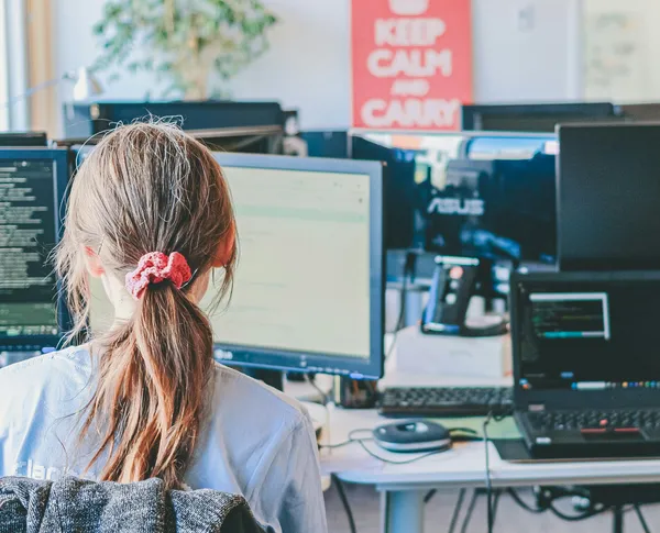 Software engineer sitting at a desk, looking at a computer.